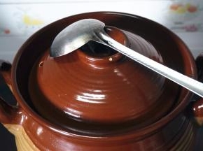 用勺子盖着砂锅盖的排气孔。