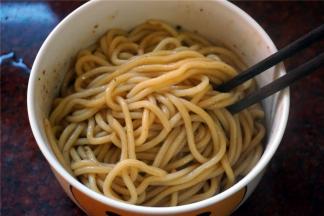 将热面条夹到碗里，并用筷子将酱料拌均匀即可。