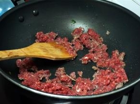 烧红锅，加入适量的花生油，然后加入瘦肉碎，快速翻炒。