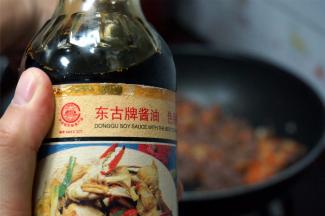 将刚才炒好的瘦肉碎加入，然后加入适量的酱油调味。