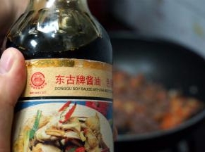 将刚才炒好的瘦肉碎加入，然后加入适量的酱油调味。