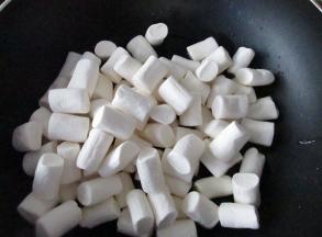 黄油融化后让人棉花糖，继续小火加热至棉花糖融化。中间要适当翻搅，以让棉花糖受热均匀