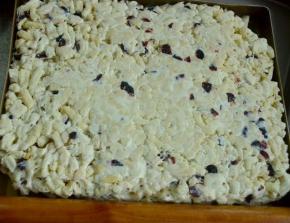 放入炸好的面条和切碎的蔓越莓干，最好的倒在不沾的油布上，快速揉压成团。这个步骤要块，以面牛轧糖晾凉后不好粘合,成团后放入不沾烤盘中，表面擀压平整，晾凉