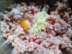 将切好的姜蒜加入肉糜中，再加入一只鸡蛋。