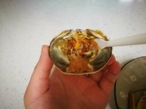 先把这里面的蟹黄吃掉，中间有个器官比较硬，不要吃，轻轻把周围的蟹黄吃掉就好，加点蟹醋在上面