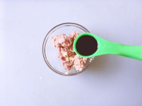 将绞好的肉放入碗中加入生姜碎，一勺生抽