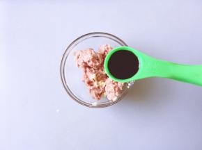 将绞好的肉放入碗中加入生姜碎，一勺生抽