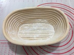 发酵篮倒少许面粉晃动，把面粉晃均为，再把多余的倒出来