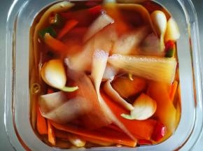 把大蒜，小米辣，红辣椒，白糖都放进去，加入生抽，老抽，我的小米辣水很多，所以我没有另加水。泡椒水不够或是怕辣的，可以添加凉开水，搅匀后，盖过萝卜，尝尝味道，淡了的加盐。怕辣的，小米辣少切些，辣椒少放些。我顺手切了几片胡萝卜扔进去了，胡萝卜切薄一点，盖好盖子，放入冰箱冷藏一晚就可以吃了