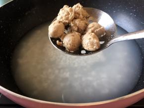 将泡好米的大米放入开水中煮开花后放入肉丸