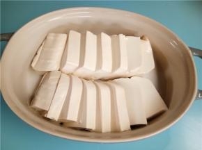 泡好的豆腐切成1厘米左右的厚度。并排放入碗中。