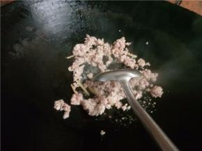 下入肉末翻炒变色后淋入料酒。