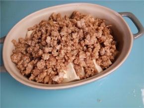 把炒好的肉末铺在豆腐上面。