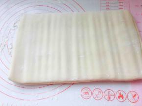 因为面团冻过，黄油冷藏过，直接擀会很容易不均匀，先用擀面杖，垂直按压，不要特别用力