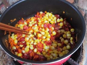 下入胡萝卜、玉米粒翻炒。