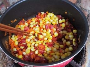 下入胡萝卜、玉米粒翻炒。