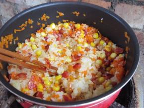 下入蒸好的糯米。用筷子划散翻炒。