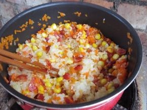 下入蒸好的糯米。用筷子划散翻炒。