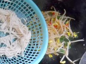 豆芽炒至八成熟，倒入金针菇，加入适量盐，炒匀。