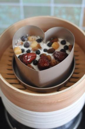 将红枣、桂圆、葡萄干铺在表面，放入蒸笼中。