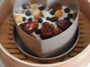 将红枣、桂圆、葡萄干铺在表面，放入蒸笼中。