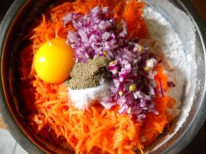 胡萝卜丝、洋葱、盐、黑胡椒粉、鸡蛋等倒入面粉中。