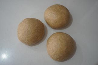 将发酵好的面团取出，按压排气，然后称重后分为三个小面团，滚圆后盖保鲜膜松弛10分钟