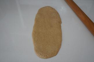 取一个松弛好的面团，光面朝下擀成椭圆