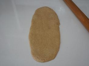 取一个松弛好的面团，光面朝下擀成椭圆