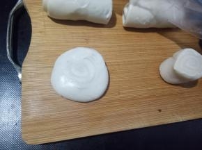 切面朝上先按扁，用擀面杖擀成中间厚，四周薄的面片。