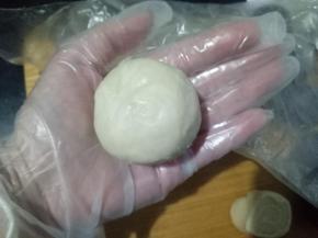 利用虎口慢慢推，这个方子很好包，不用担心推不上去。包好后收口捏紧。收口朝下整理成自己满意的蛋黄酥形状。