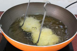 锅中倒入适量的油，油温到达130度左右，把整个模具和茄子一起放入锅中炸