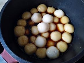 将圆子捞出，放入红糖水中小火煮片刻，让圆子表面裹满红糖水，即可捞出装盘