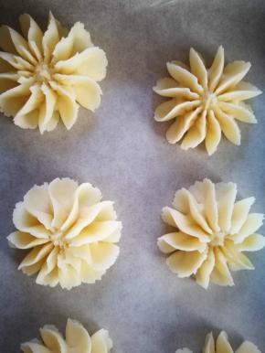 挤曲奇要多练哈，手垂直，紧贴油纸慢慢的挤，一定大小后，往下捎按一下，然后一提就好了 有那种曲奇硅胶垫卖，有图案，很方便，每个曲奇之间要有些距离，曲奇在烤的过程中会膨胀