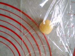 将每个小剂子放入保鲜膜，两面都有保鲜膜覆盖，防粘