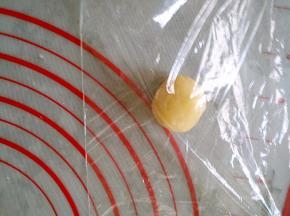 将每个小剂子放入保鲜膜，两面都有保鲜膜覆盖，防粘