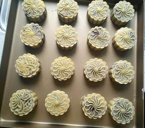 月饼烘烤5分钟后取出，刷蛋液，继续烘烤15分钟