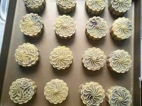 月饼烘烤5分钟后取出，刷蛋液，继续烘烤15分钟