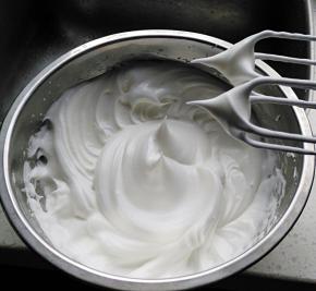 将蛋清分三次加入60克白糖，打发至干性发泡