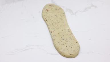 松弛后轻拍，翻面擀长。