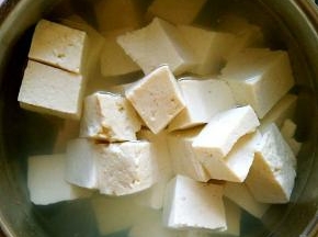 老豆腐切成小块，放在开水中加入少许盐，泡10分钟。
