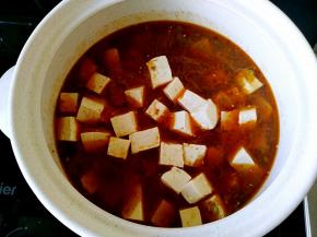 把炝好的汤汁倒在砂锅中，倒入老豆腐块儿。