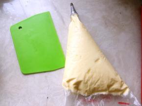 裱花袋装入中号圆形裱花嘴，将打发好的酱装入裱花袋内，排出空气