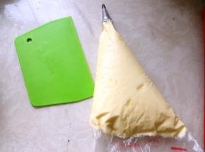 裱花袋装入中号圆形裱花嘴，将打发好的酱装入裱花袋内，排出空气