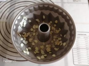 模具里面涂抹一些融化的黄油，撒上适量的杏仁片。