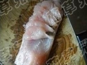 横向斜刀切成连体鱼片（鱼皮不切断）。 切好的鱼片鱼皮都还连着。