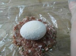 鸡蛋上滚一层面粉(这里面粉最好稍微多滚一点，不然烤熟后切开容易鸡蛋、肉分离)放在肉末上