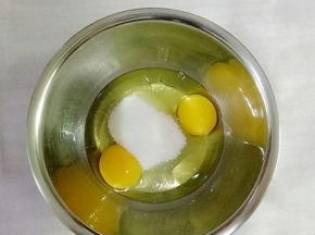 鸡蛋打入盆中，加入50g白砂糖（在准备一个盆里面放入热水，把鸡蛋盆放入热水盆中，有利于全蛋打发）