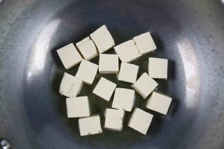 炒锅里加入适量的油，加至5成热后放入豆腐，小火加热。