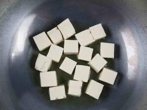 炒锅里加入适量的油，加至5成热后放入豆腐，小火加热。